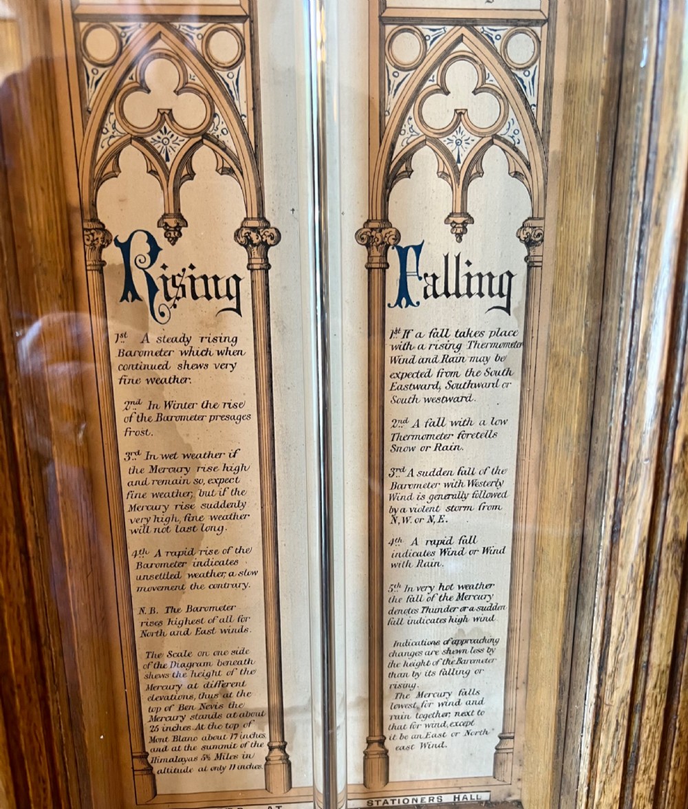 A 19th-century carved oak Admiral Fitzroy wall barometer featuring architectural details, an arched cresting, and a detailed paper weather register. View III
