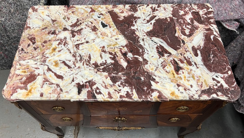 A nineteenth-century French Louis XV style commode with a contoured marble top, intricate floral marquetry, twin drawers, and cast gilt-bronze ormolu mounts. View II