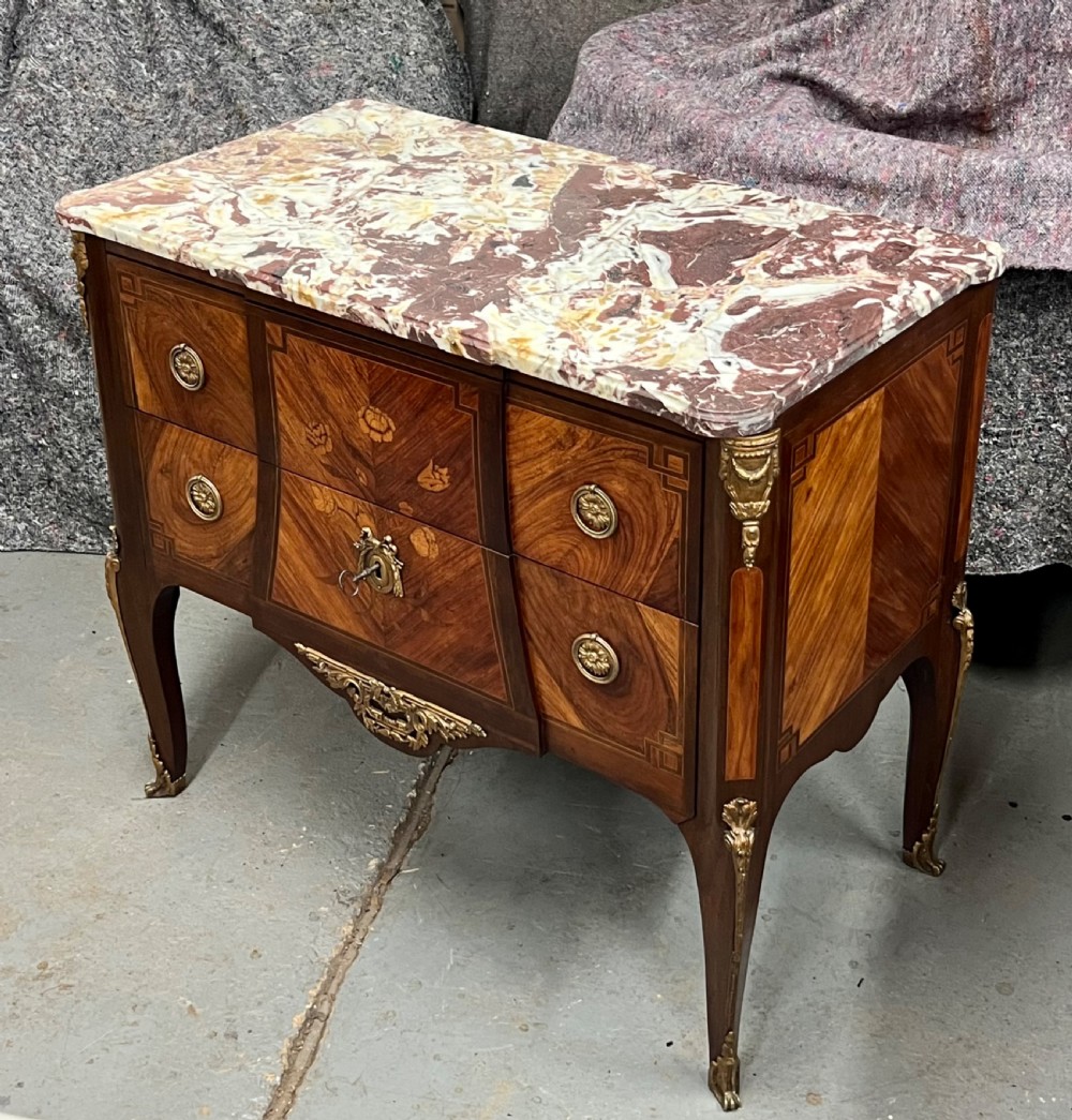 A nineteenth-century French Louis XV style commode with a contoured marble top, intricate floral marquetry, twin drawers, and cast gilt-bronze ormolu mounts. View V