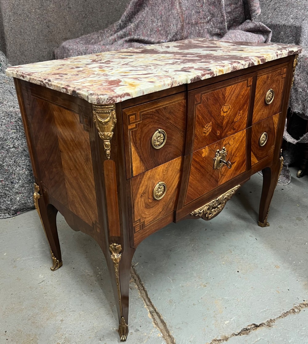 A nineteenth-century French Louis XV style commode with a contoured marble top, intricate floral marquetry, twin drawers, and cast gilt-bronze ormolu mounts. View IX