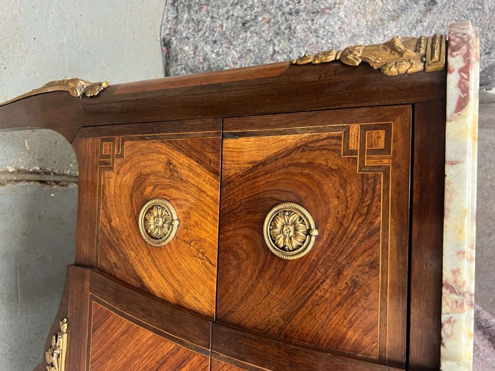 A nineteenth-century French Louis XV style commode with a contoured marble top, intricate floral marquetry, twin drawers, and cast gilt-bronze ormolu mounts. View XIV