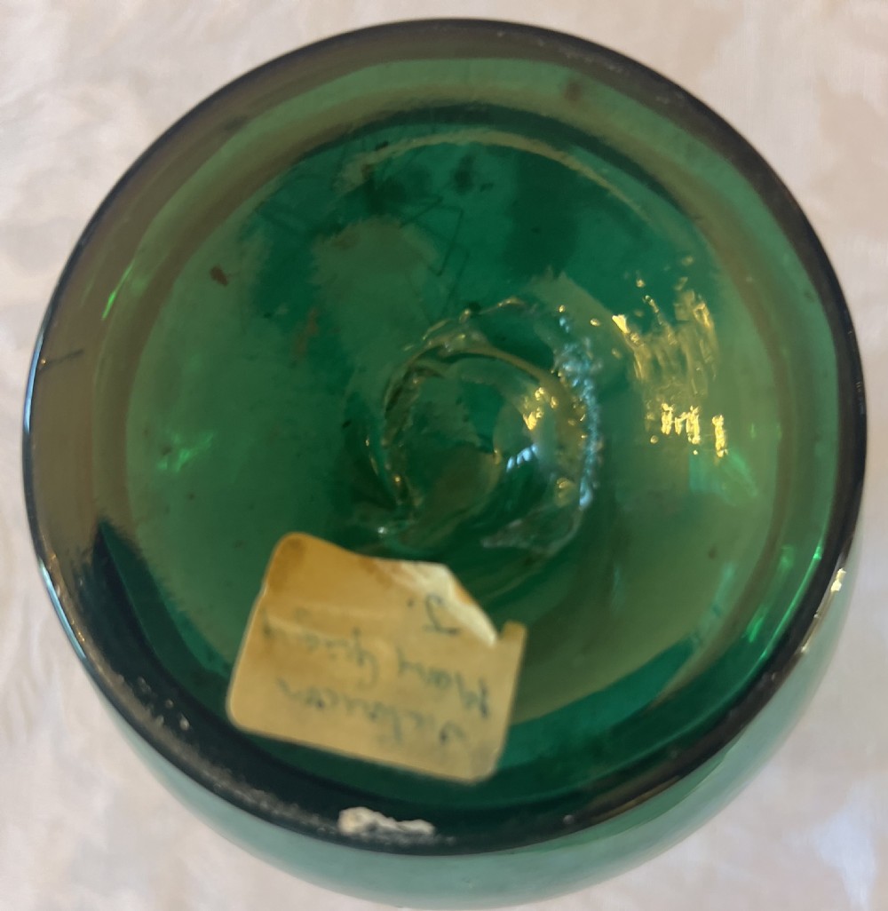 An emerald green glass vase featuring a white enamel painted scene of a child holding a plant sprig. View VI