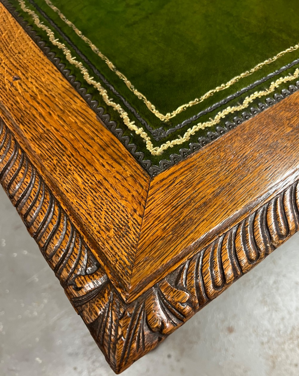 A 19th-century carved oak writing table featuring a green leather inset top, carved frieze, barley twist legs, and a central stretcher with finial. View II