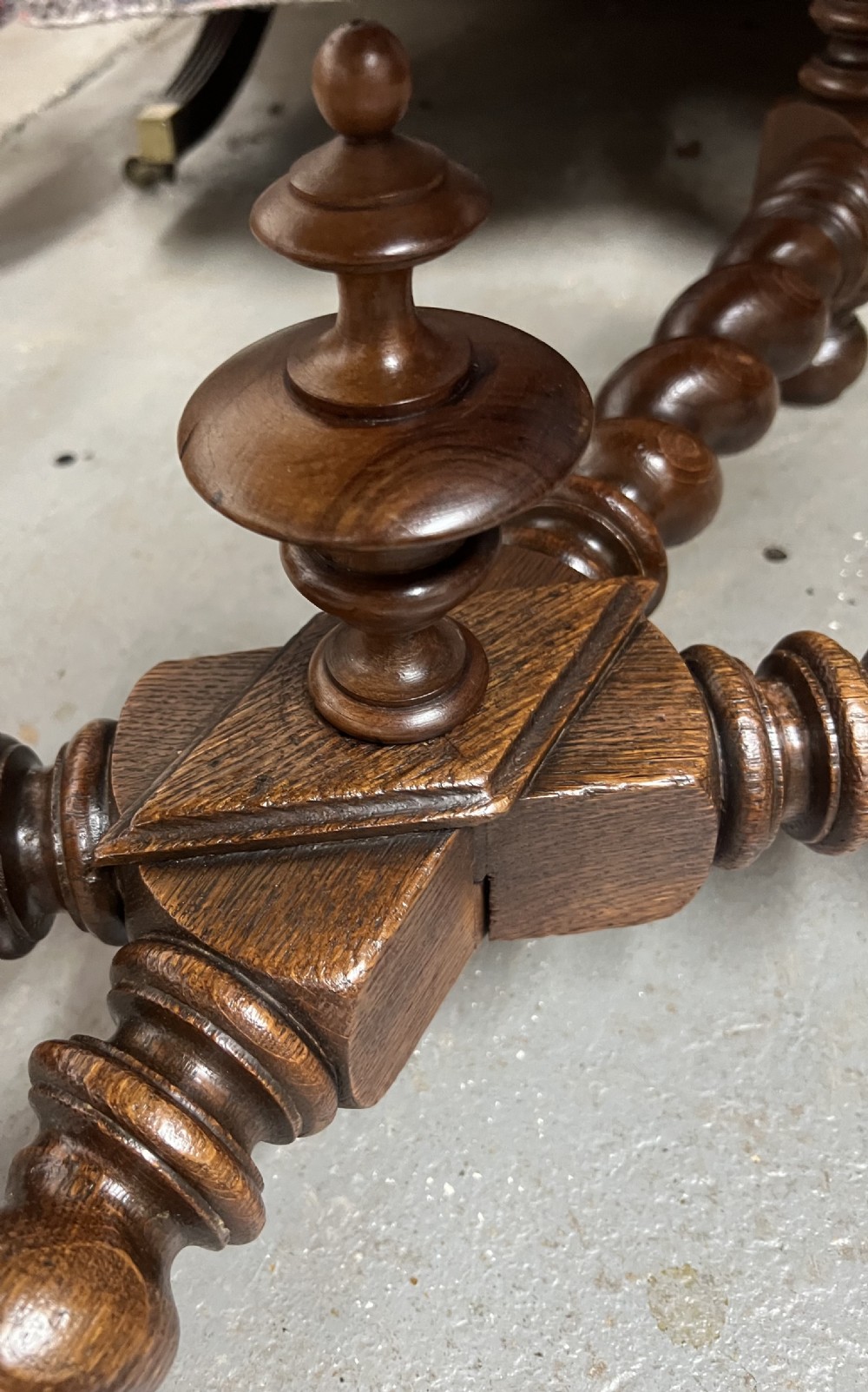 A 19th-century carved oak writing table featuring a green leather inset top, carved frieze, barley twist legs, and a central stretcher with finial. View VI