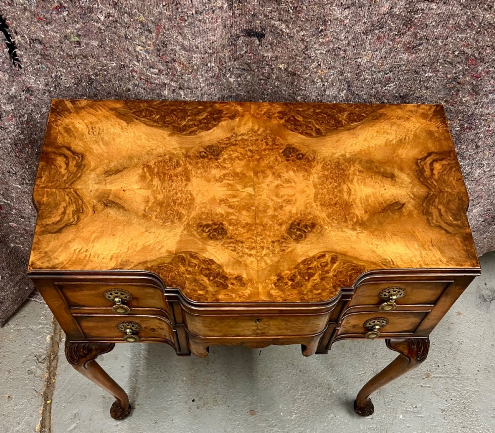 A burr walnut lowboy side table featuring five drawers, brass drop handles, a shaped apron, and four cabriole legs. View III