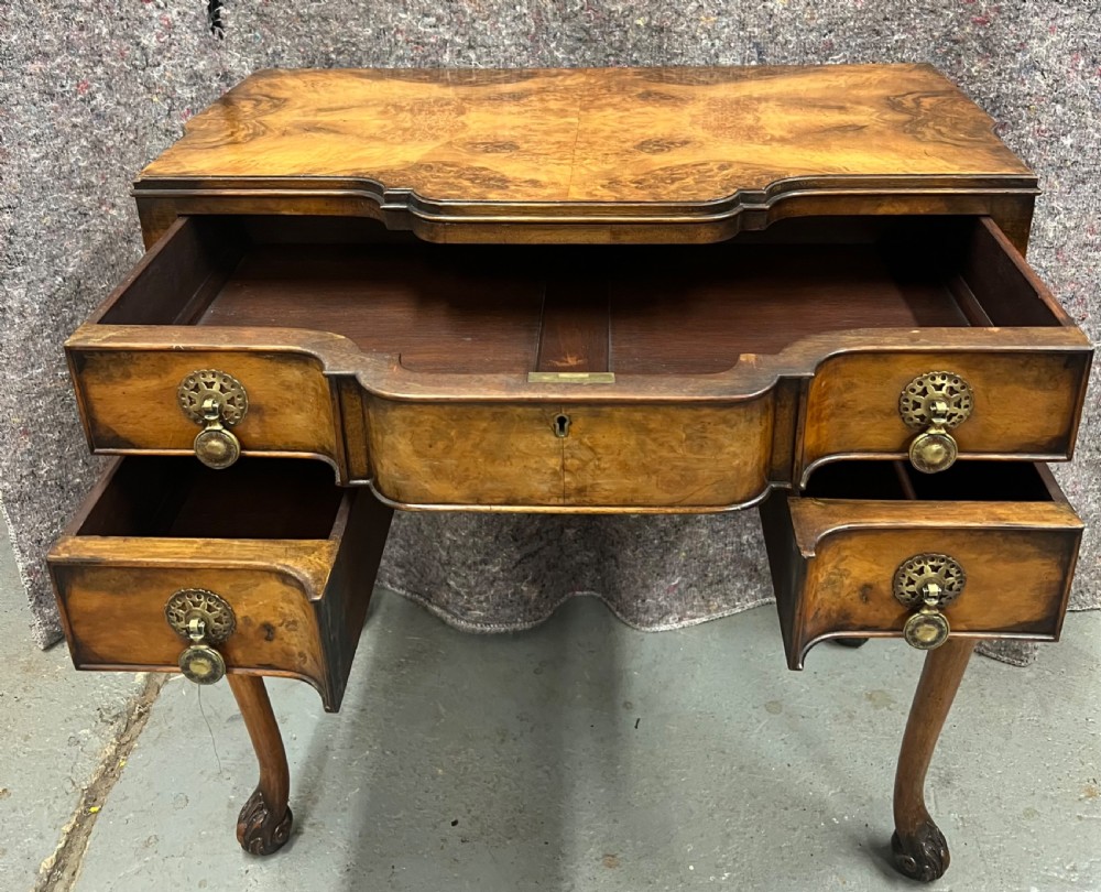 A burr walnut lowboy side table featuring five drawers, brass drop handles, a shaped apron, and four cabriole legs. View IV