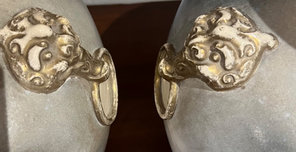 A pair of large Japanese Satsuma earthenware vases featuring painted blue and grey peonies, molded lion head handles, and a crackled cream glaze. View IX