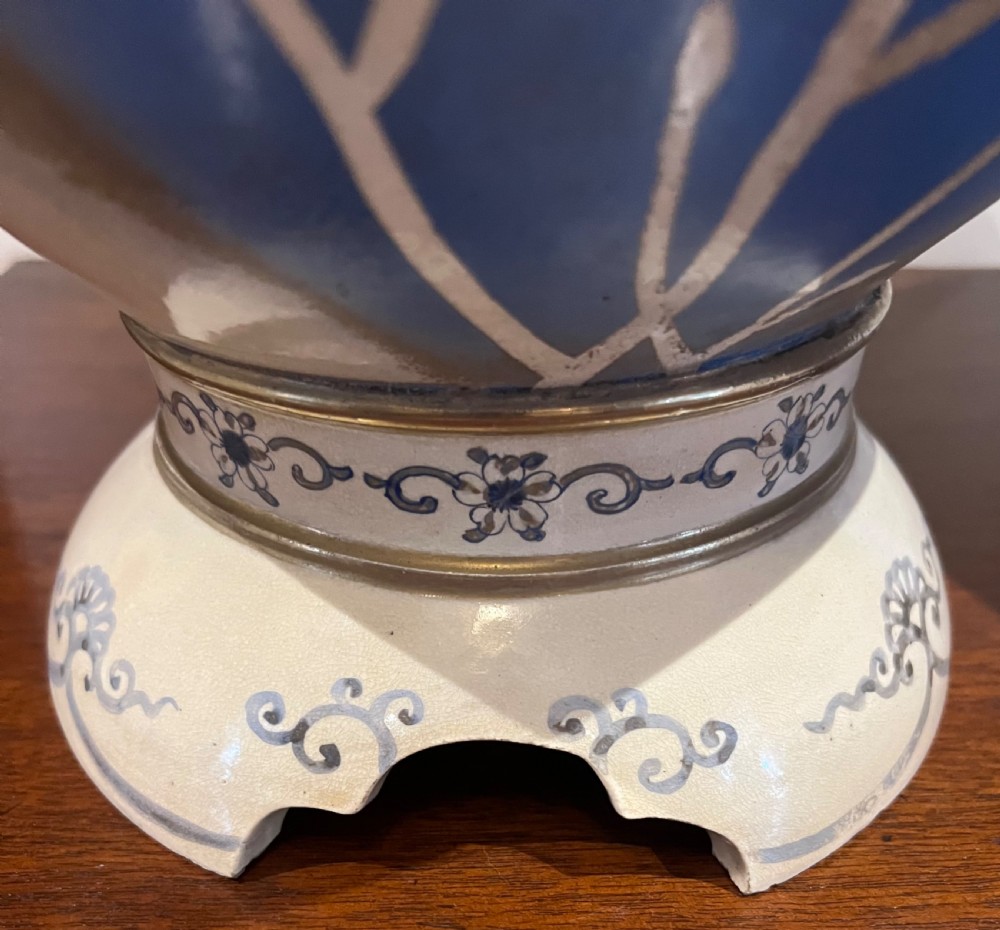 A pair of large Japanese Satsuma earthenware vases featuring painted blue and grey peonies, molded lion head handles, and a crackled cream glaze. View X