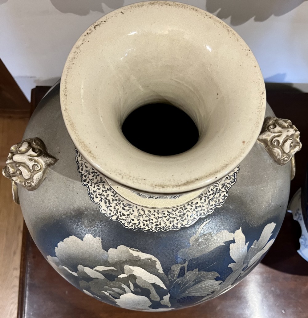 A pair of large Japanese Satsuma earthenware vases featuring painted blue and grey peonies, molded lion head handles, and a crackled cream glaze. View XII