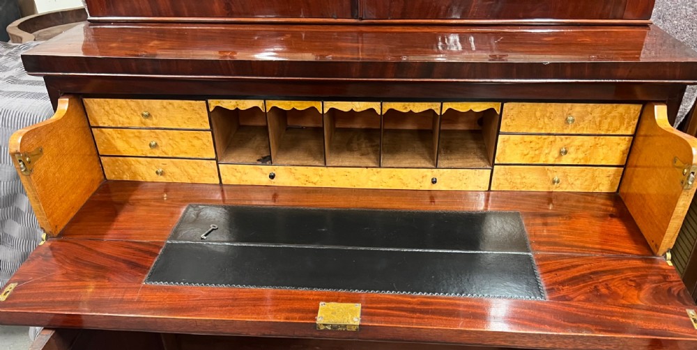 An antique mahogany secretaire bookcase featuring glazed upper doors, a middle drawer with turned knobs, and a double-door lower cabinet. View III