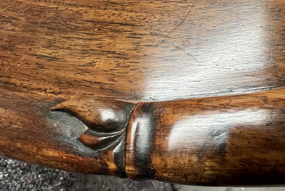 An oval brown hardwood coffee table with carved faux bamboo trim on a folding base. View IV