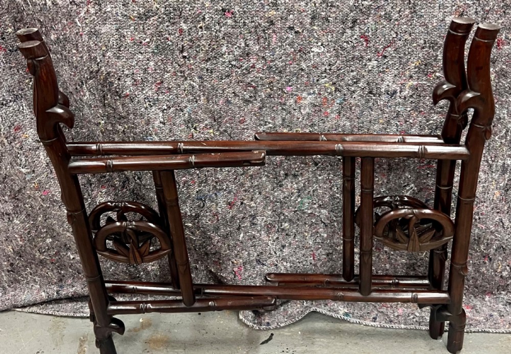 An oval brown hardwood coffee table with carved faux bamboo trim on a folding base. View VII