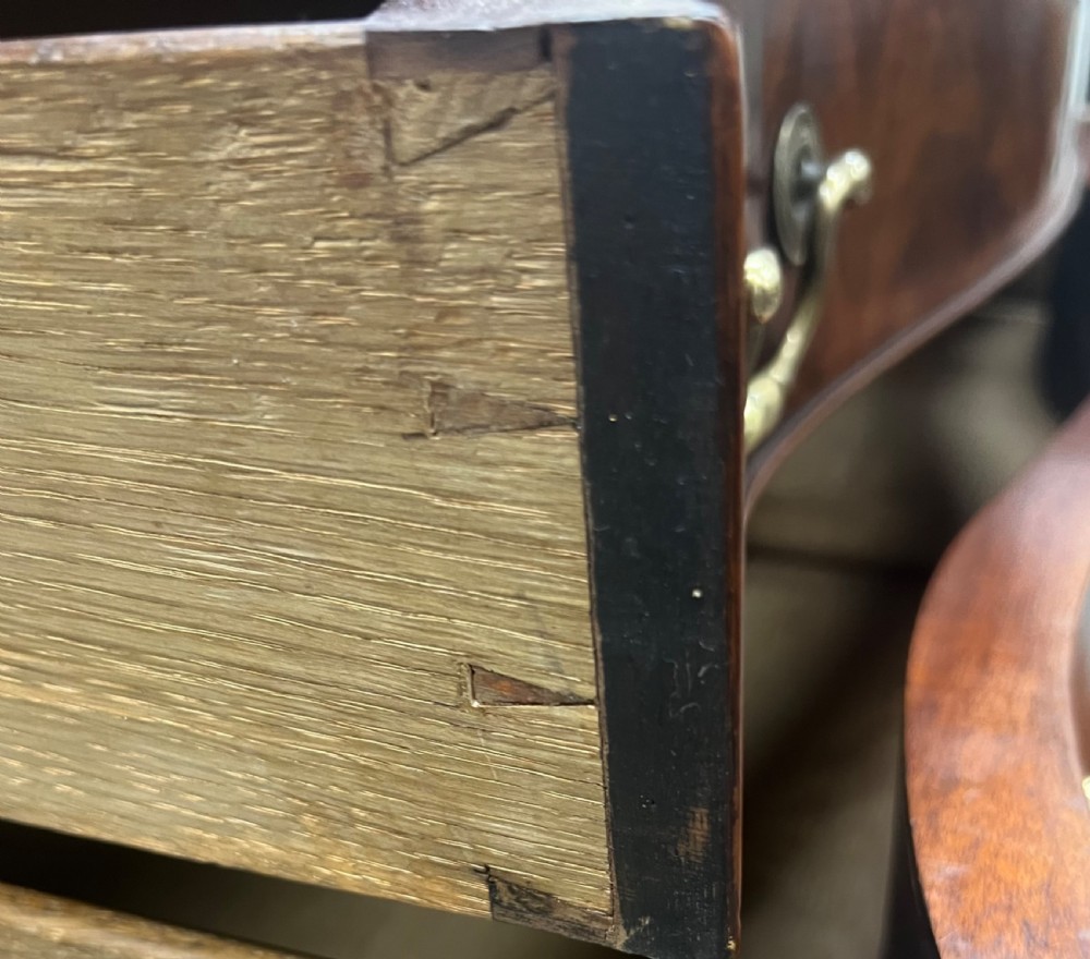 A Chippendale style mahogany chest of drawers featuring a serpentine front facade, carved blind fretwork canted corners, brass swan-neck handles, and bracket feet. View VIII