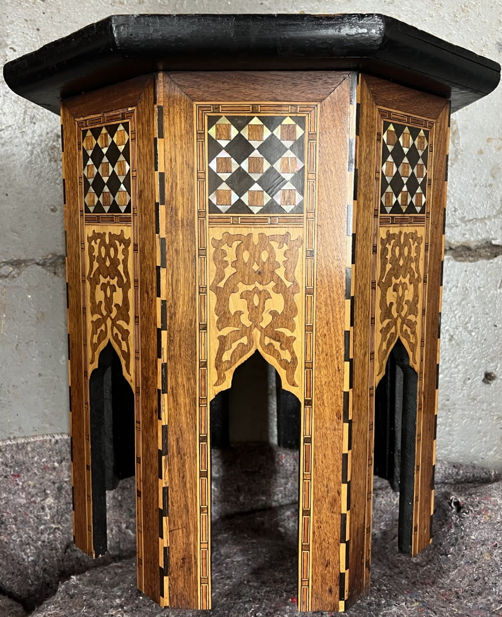 An octagonal wooden side table decorated with intricate mother-of-pearl, bone, and marquetry geometric patterns and central Arabic calligraphy. View III