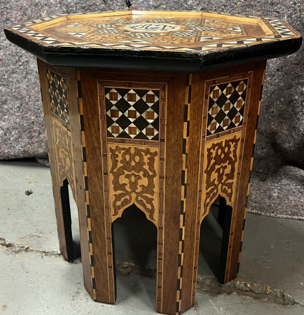 An octagonal wooden side table decorated with intricate mother-of-pearl, bone, and marquetry geometric patterns and central Arabic calligraphy. View VI