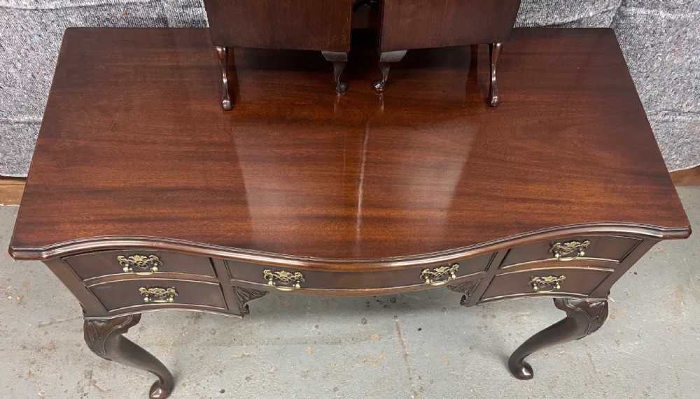 A dark mahogany serpentine dressing table featuring five drawers, cabriole legs, and an adjustable tri-fold mirror. View II