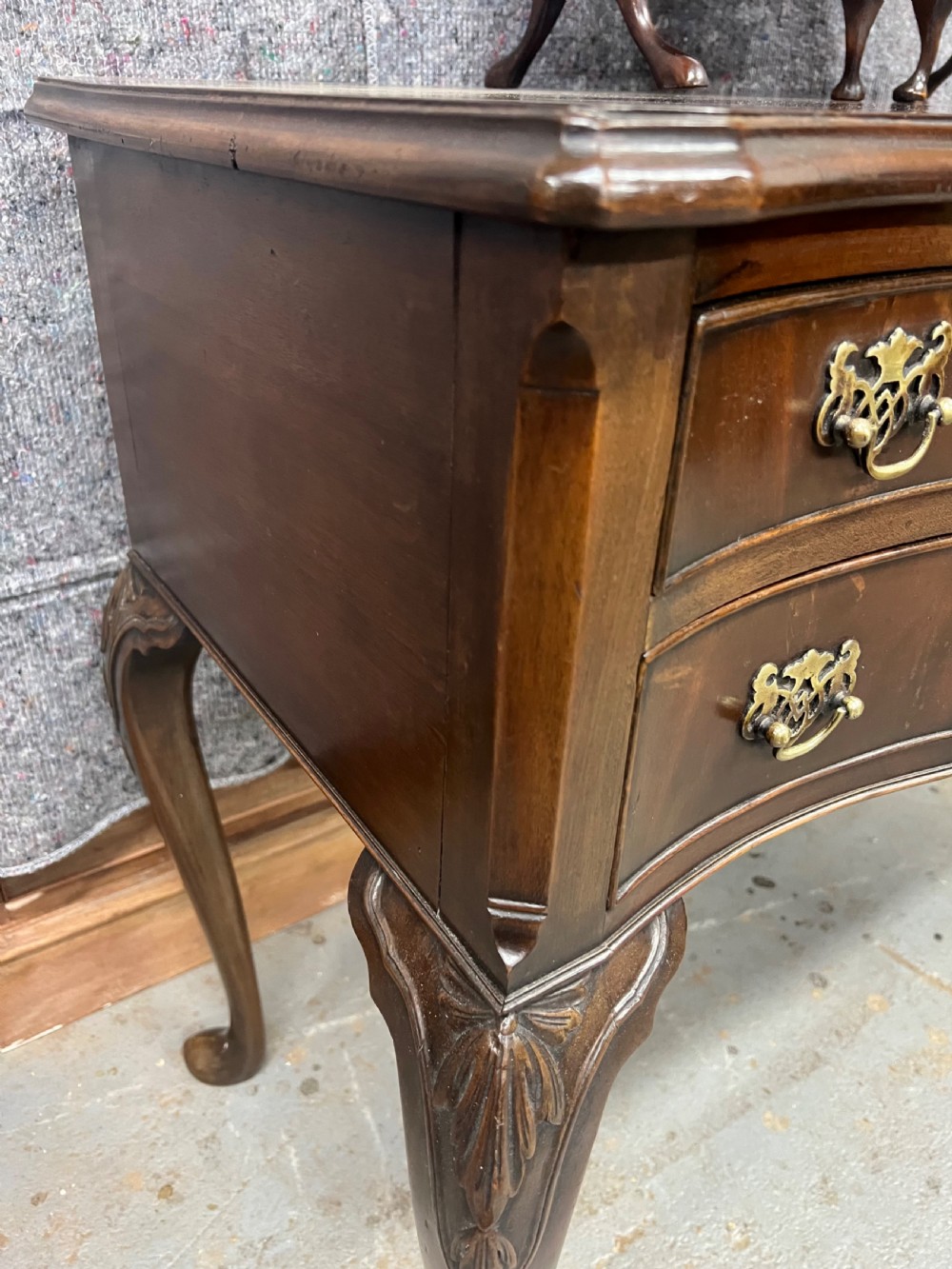A dark mahogany serpentine dressing table featuring five drawers, cabriole legs, and an adjustable tri-fold mirror. View VI