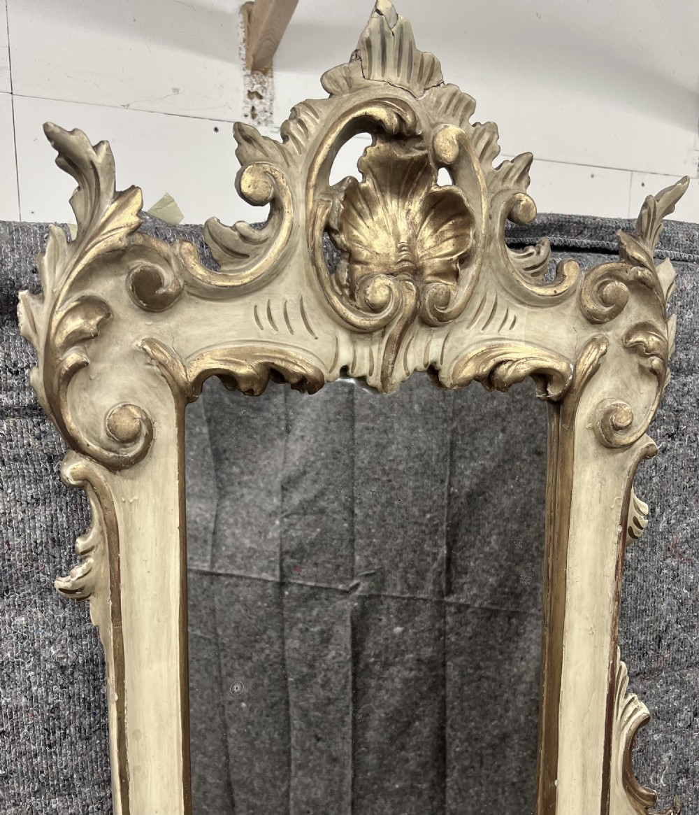 An ornate cream-painted and parcel-gilt Venetian Rococo console table featuring an asymmetrical tall mirror, tiered display shelves, and scrolling cabriole legs. View VII