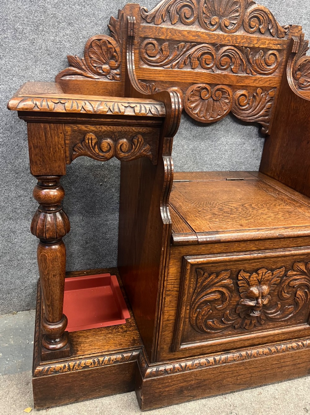 An antique carved oak hall stand set featuring a top wall-mounted mirror with coat pegs and a matching lower bench with integrated umbrella holders. View IV