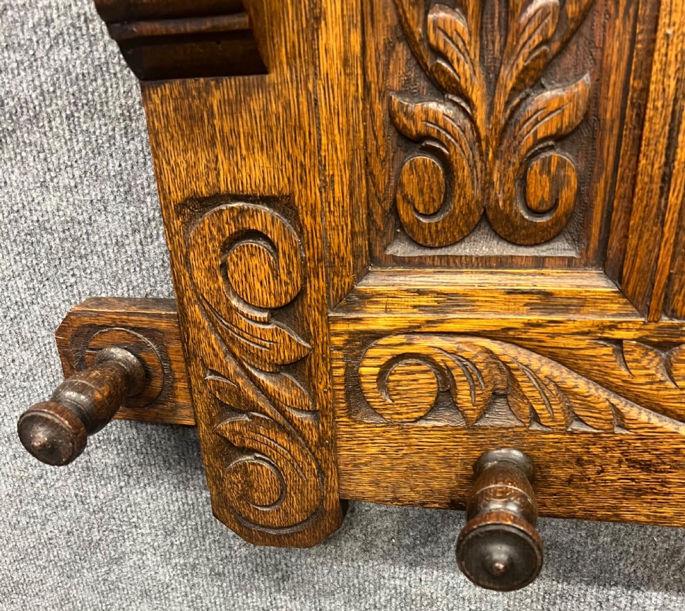 An antique carved oak hall stand set featuring a top wall-mounted mirror with coat pegs and a matching lower bench with integrated umbrella holders. View VIII