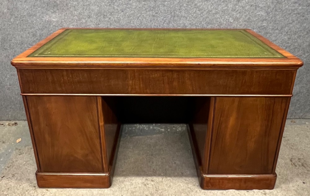 A nineteenth-century mahogany pedestal desk featuring a green leather writing top and nine drawers with turned wooden handles. View III