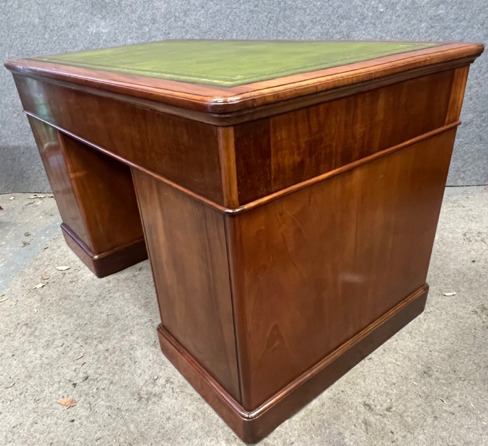 A nineteenth-century mahogany pedestal desk featuring a green leather writing top and nine drawers with turned wooden handles. View VIII