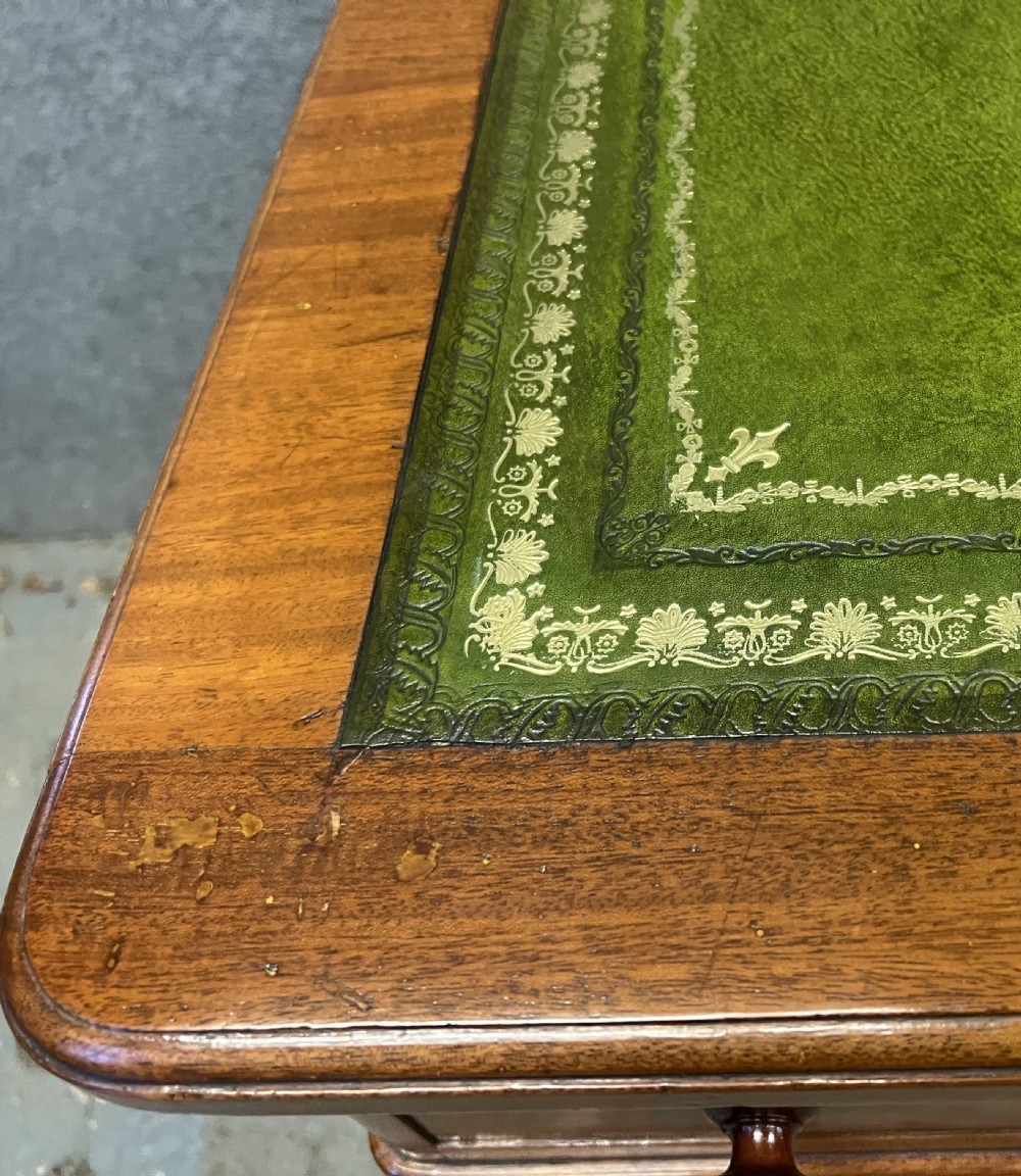 A nineteenth-century mahogany pedestal desk featuring a green leather writing top and nine drawers with turned wooden handles. View IX