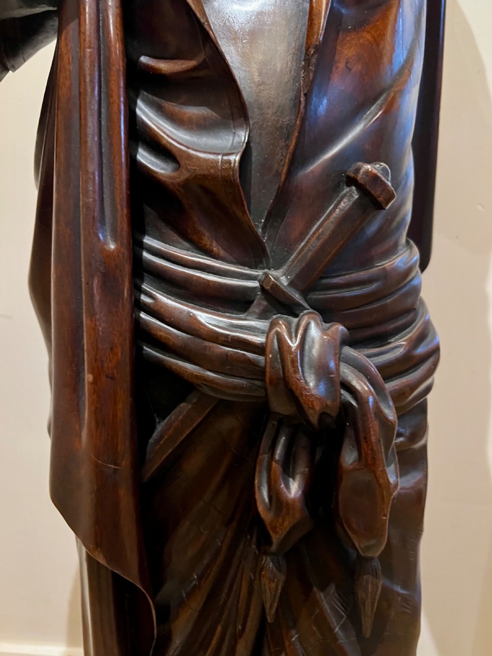 A 19th-century carved dark wood figural floor lamp depicting a draped male figure holding an illuminated flame glass urn on a octagonal base. View VI