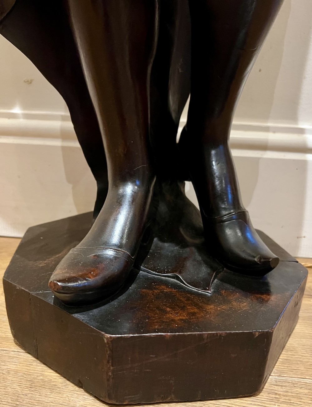A 19th-century carved dark wood figural floor lamp depicting a draped male figure holding an illuminated flame glass urn on a octagonal base. View VII