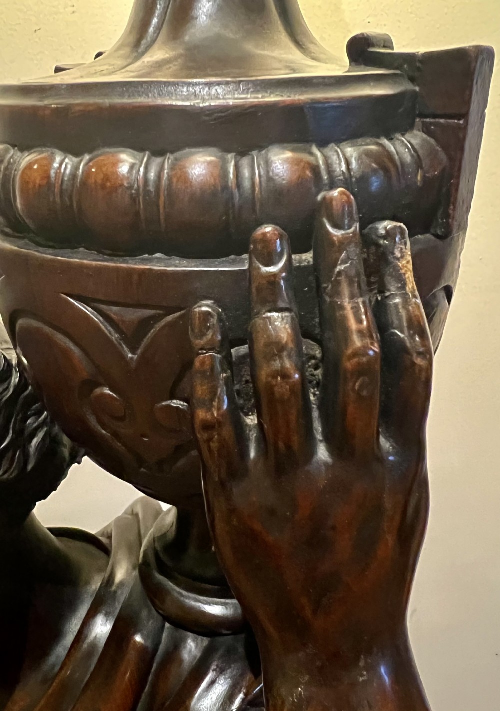A 19th-century carved dark wood figural floor lamp depicting a draped male figure holding an illuminated flame glass urn on a octagonal base. View XI