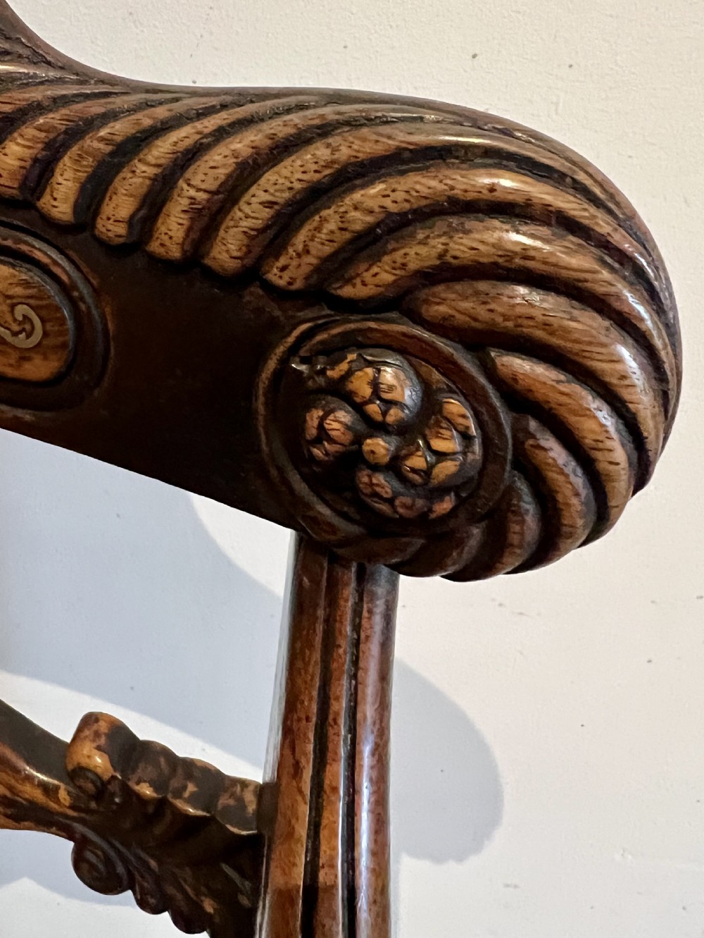 A Regency rosewood elbow chair featuring brass inlay along the top rail, curved scroll arms, a carved central splat, reeded front legs, and a colourful botanical upholstered seat. View VIII