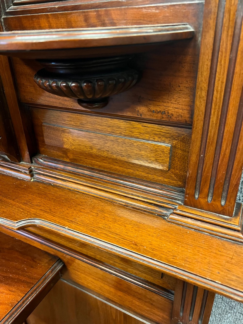 A tall Victorian carved walnut hall stand featuring brass coat hooks, bevelled mirrors, a central carved cupboard, and lower umbrella rails. View III