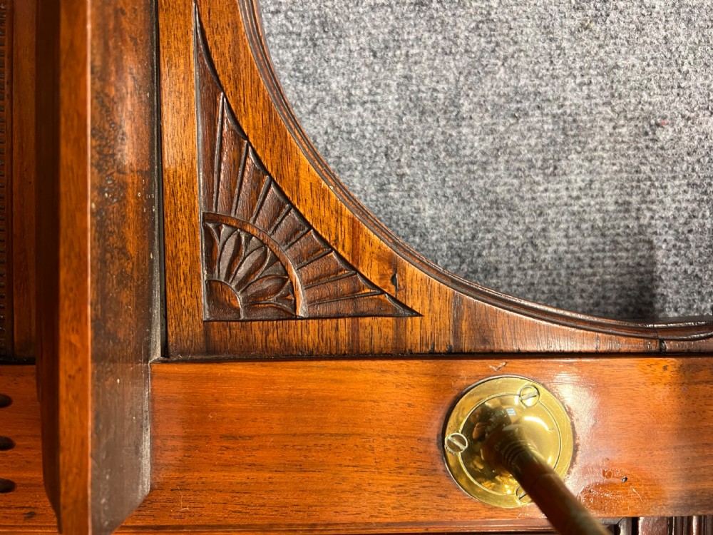 A tall Victorian carved walnut hall stand featuring brass coat hooks, bevelled mirrors, a central carved cupboard, and lower umbrella rails. View IV