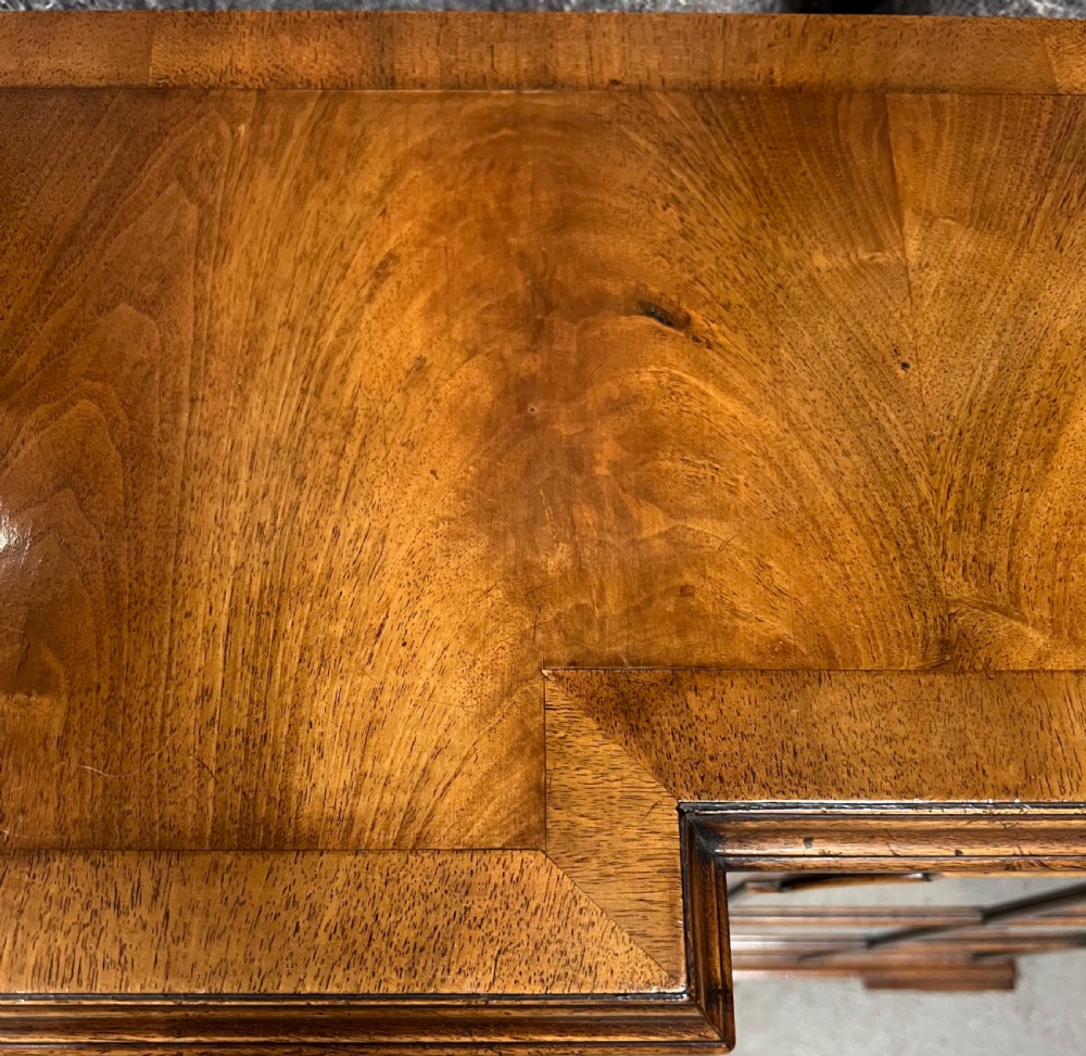 A low Queen Anne style walnut dwarf bookcase featuring a breakfront design with glazed side doors, a central veneered cupboard door, and bracket feet. View VIII
