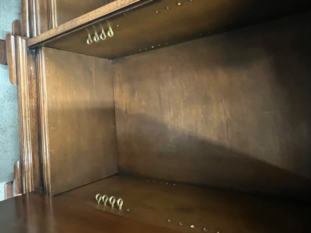 A low Queen Anne style walnut dwarf bookcase featuring a breakfront design with glazed side doors, a central veneered cupboard door, and bracket feet. View X