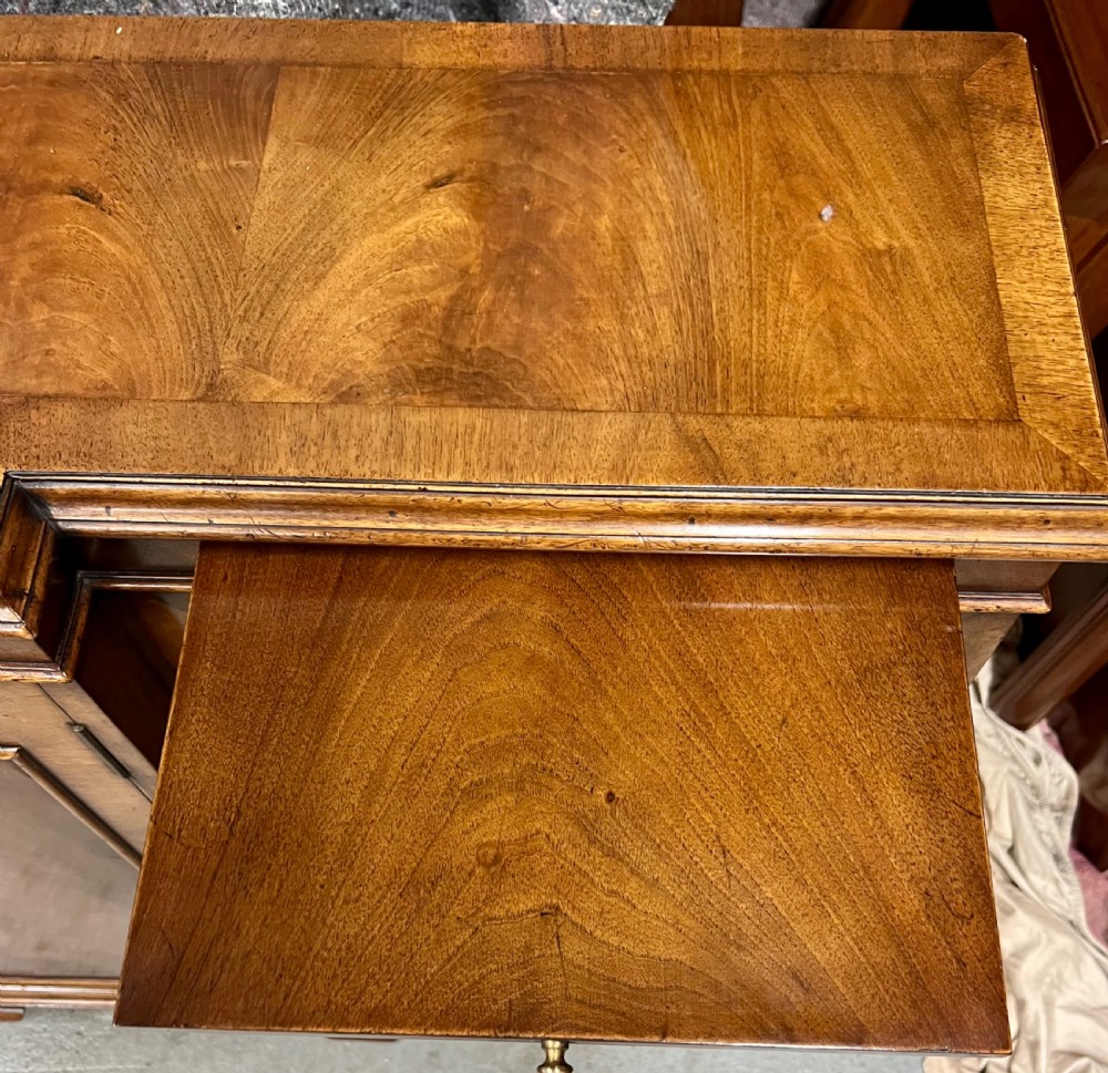 A low Queen Anne style walnut dwarf bookcase featuring a breakfront design with glazed side doors, a central veneered cupboard door, and bracket feet. View XI
