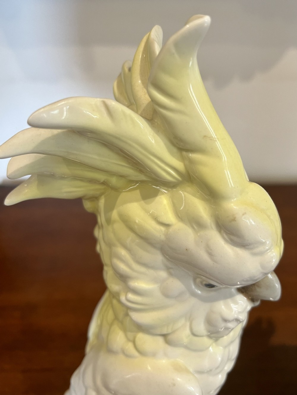 A pair of glazed porcelain cockatoo figurines perched on stylized foliage branches, one featuring a yellow crest and the other a soft pink crest. View IV