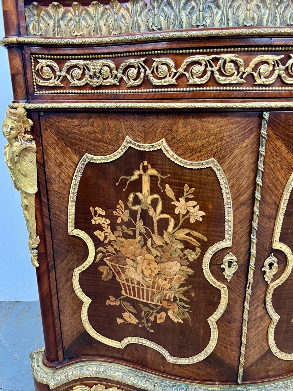A pair of French Louis XV style kingwood side cabinets featuring floral marquetry, gilt-bronze ormolu mounts, and shaped pink marble tops. View IV