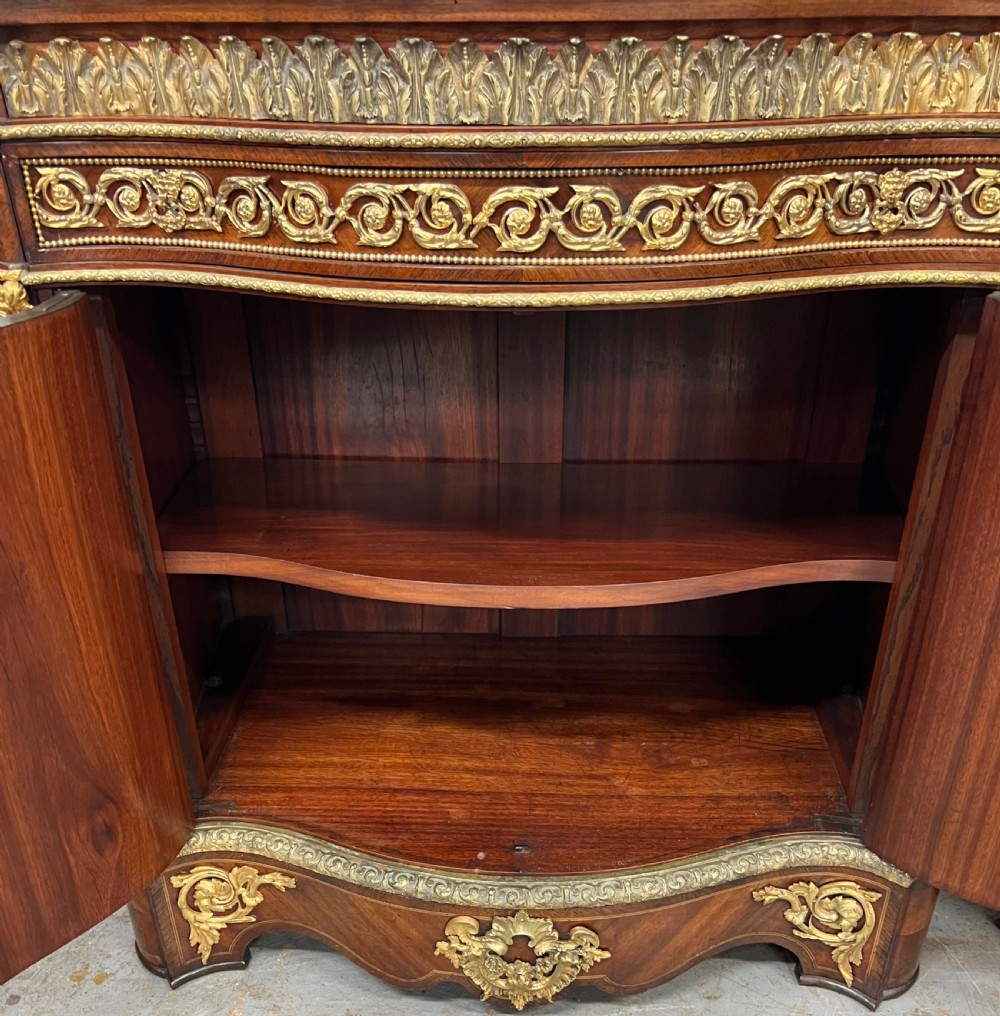 A pair of French Louis XV style kingwood side cabinets featuring floral marquetry, gilt-bronze ormolu mounts, and shaped pink marble tops. View V