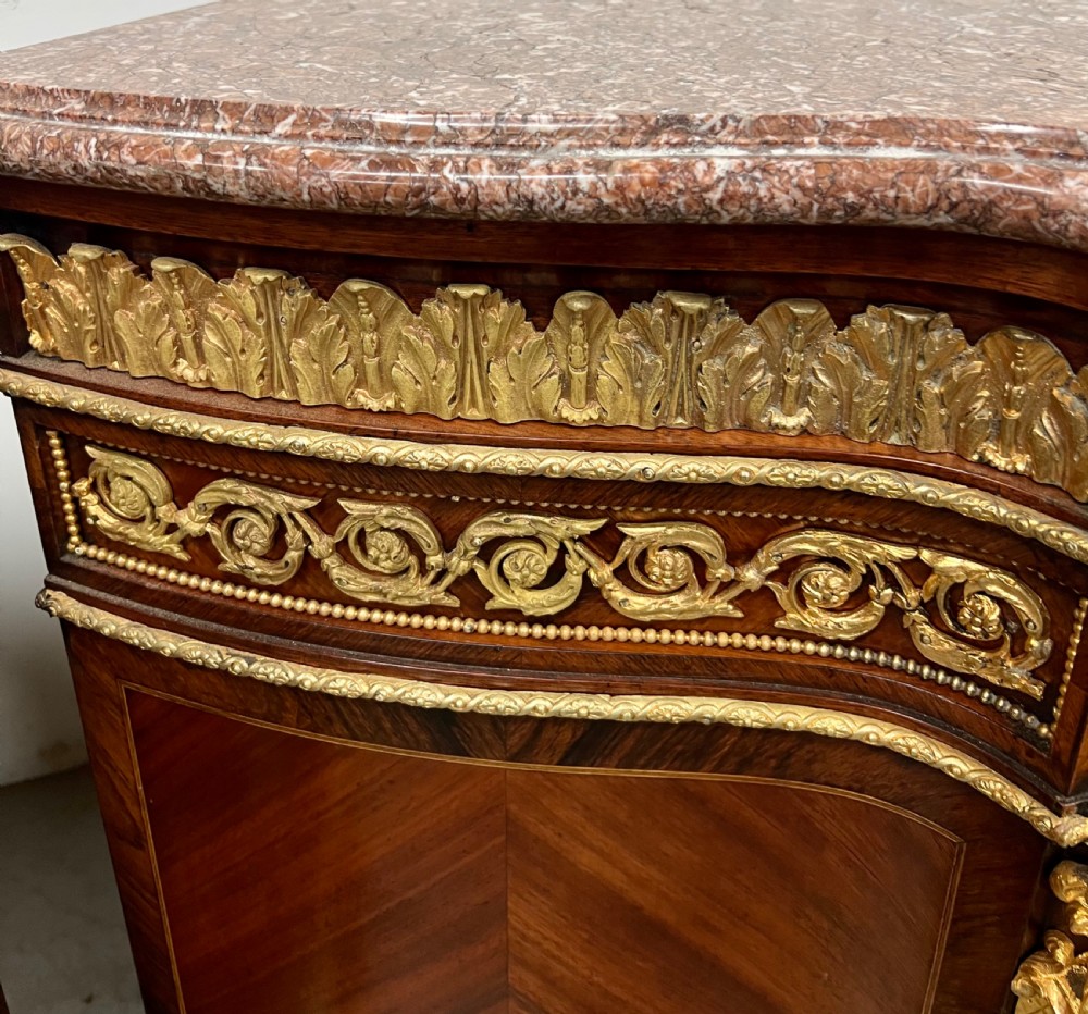 A pair of French Louis XV style kingwood side cabinets featuring floral marquetry, gilt-bronze ormolu mounts, and shaped pink marble tops. View X