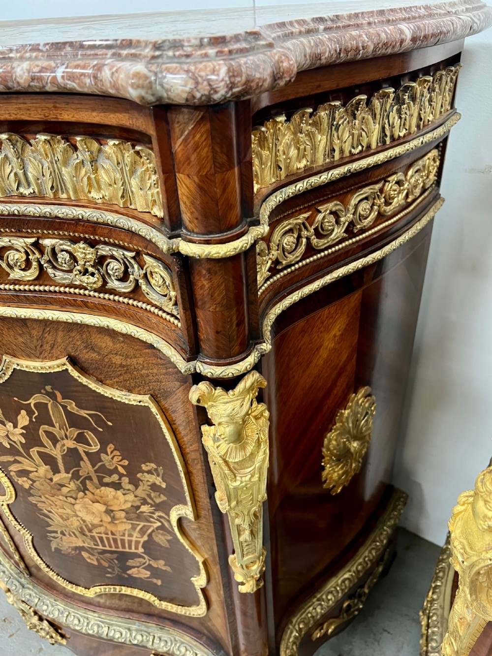 A pair of French Louis XV style kingwood side cabinets featuring floral marquetry, gilt-bronze ormolu mounts, and shaped pink marble tops. View XVIII