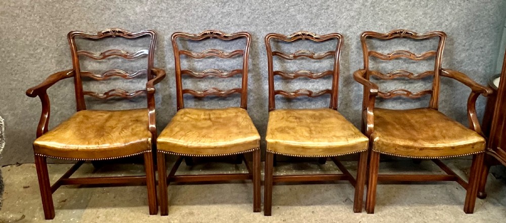 A set of eight Chippendale style mahogany dining chairs featuring serpentine ladderback splats and tan leather drop-in seats, including six side chairs and two carver armchairs. View II