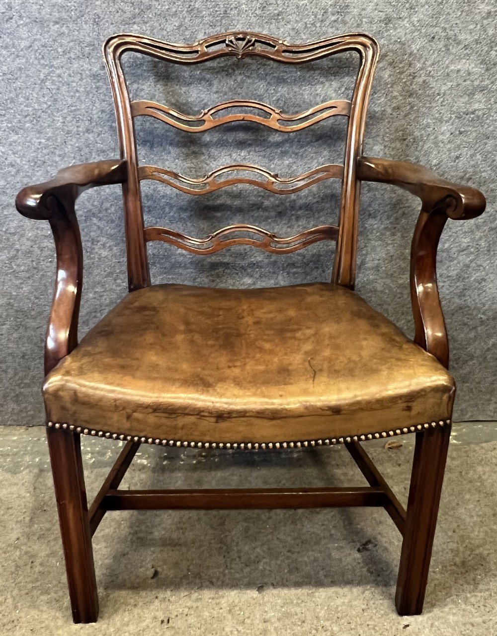 A set of eight Chippendale style mahogany dining chairs featuring serpentine ladderback splats and tan leather drop-in seats, including six side chairs and two carver armchairs. View III