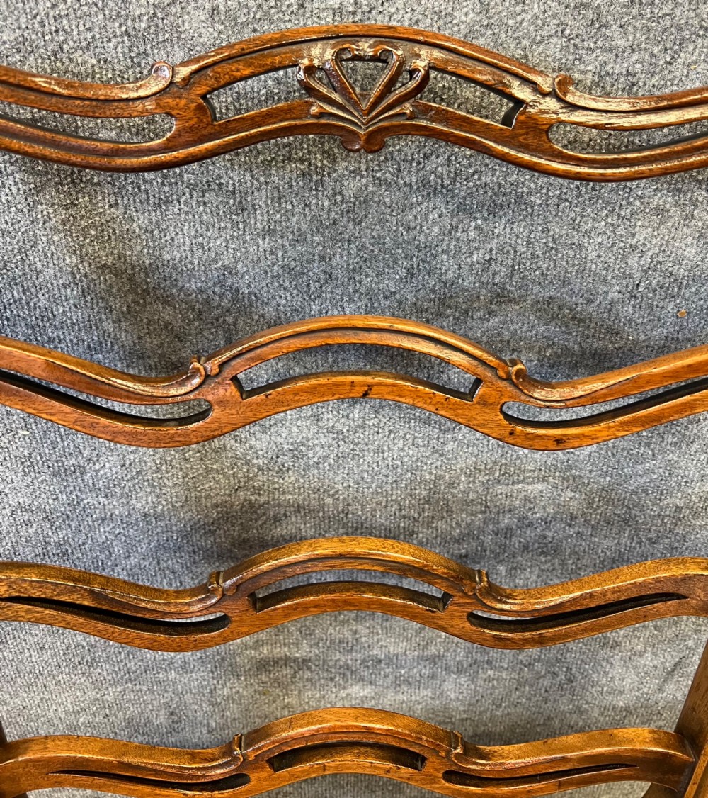 A set of eight Chippendale style mahogany dining chairs featuring serpentine ladderback splats and tan leather drop-in seats, including six side chairs and two carver armchairs. View IV