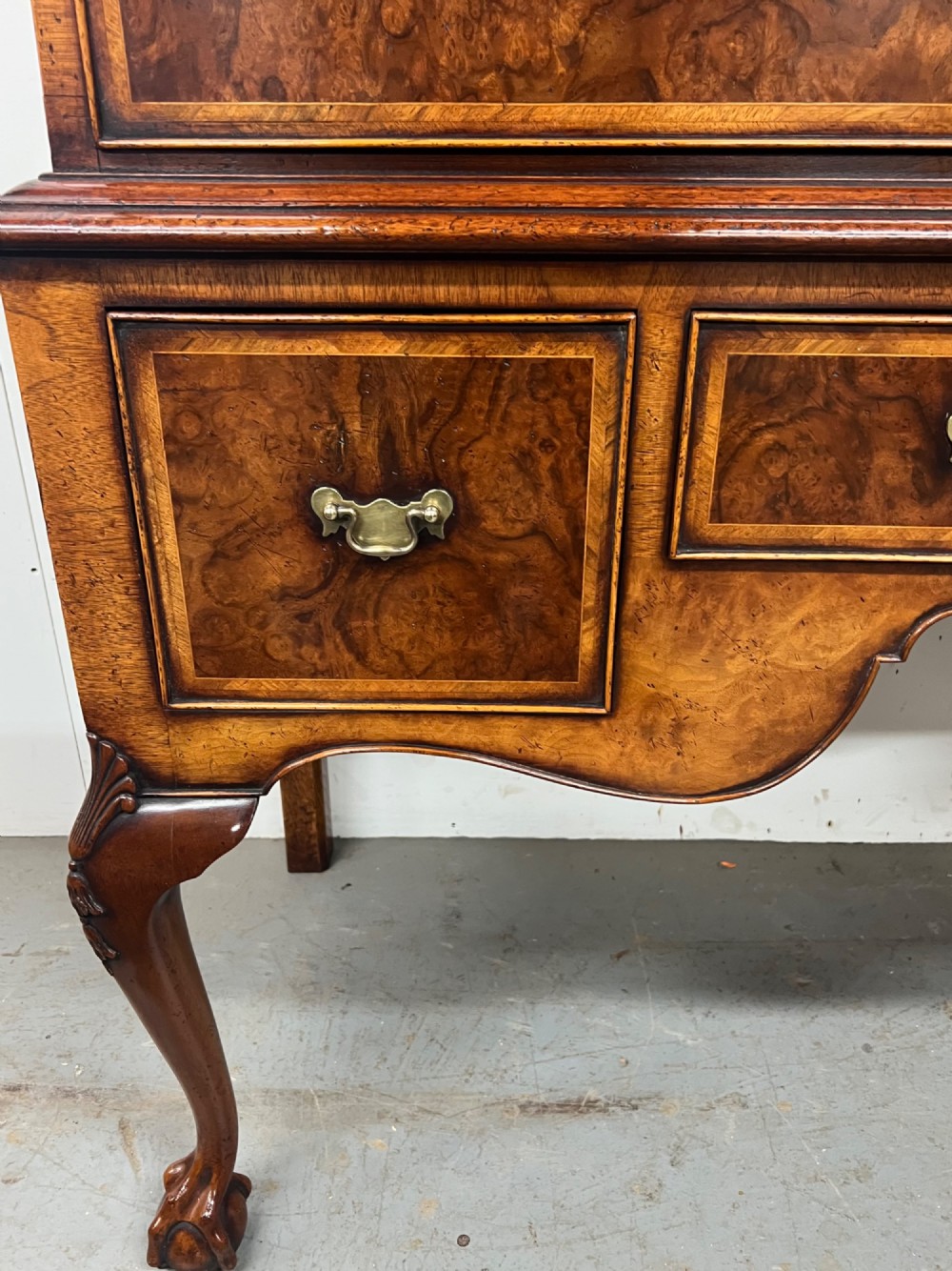 A tall burr walnut chest on stand featuring two short over three long drawers on top, three lower drawers, a shaped apron, and carved cabriole legs. View II