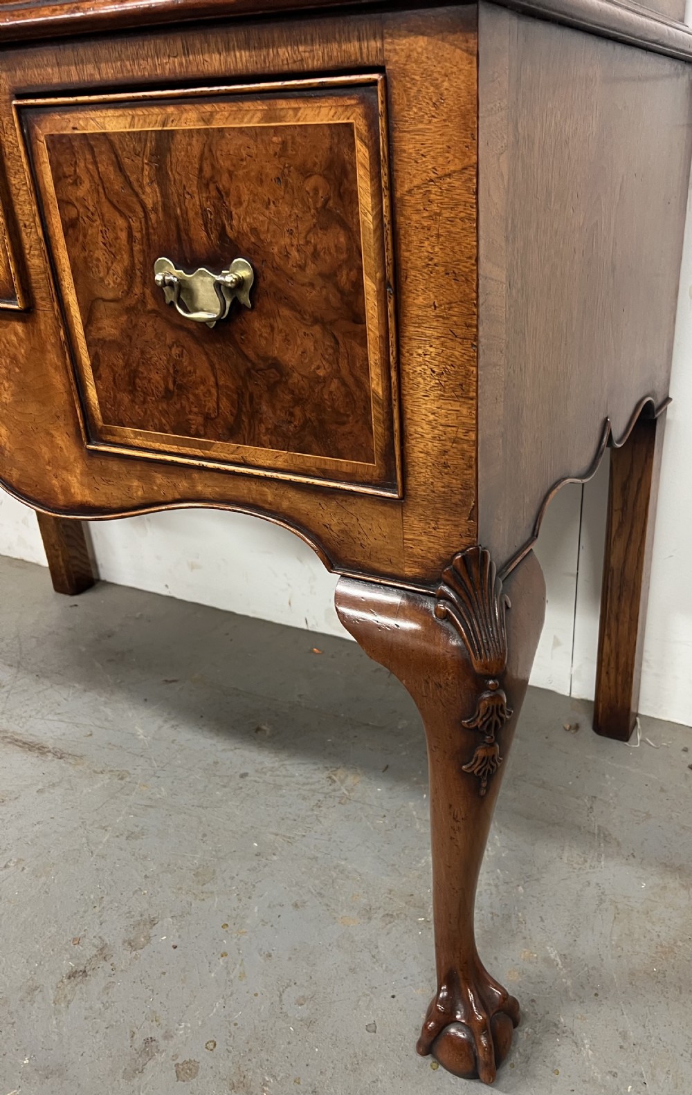 A tall burr walnut chest on stand featuring two short over three long drawers on top, three lower drawers, a shaped apron, and carved cabriole legs. View III