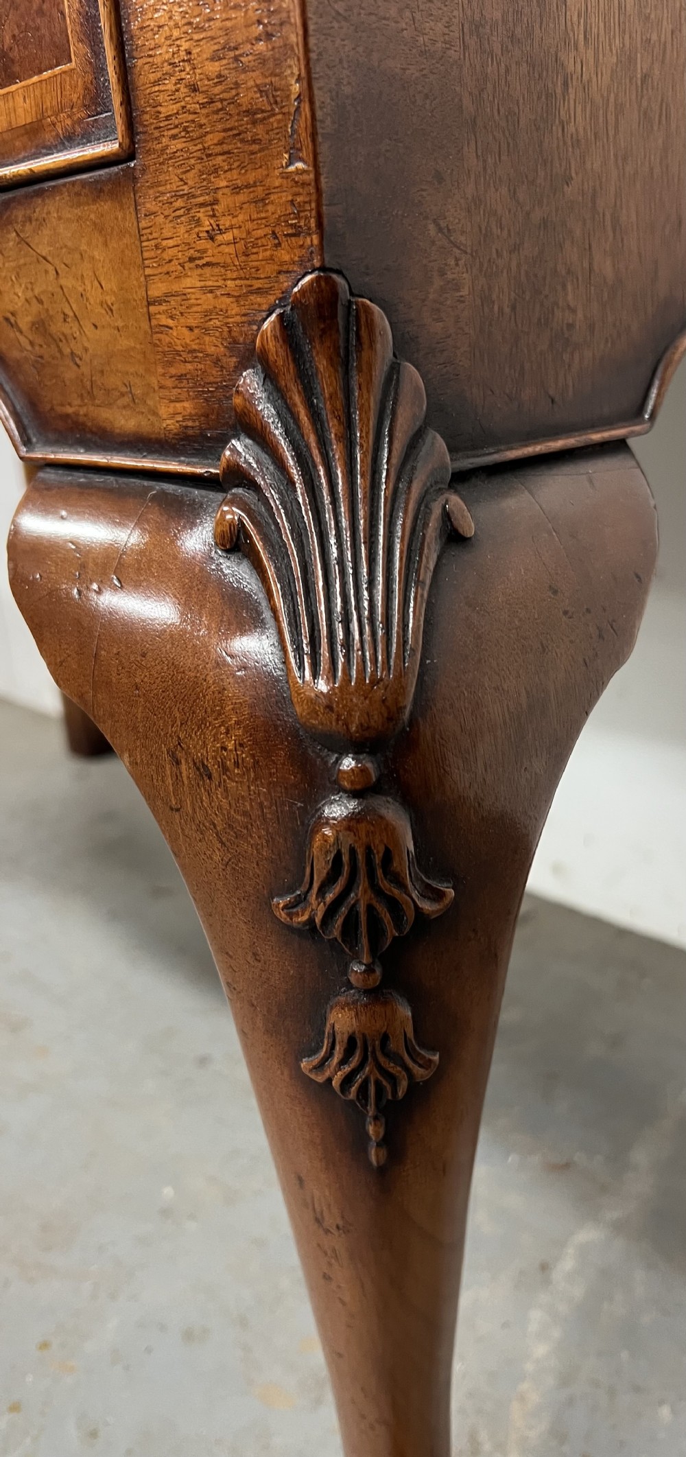 A tall burr walnut chest on stand featuring two short over three long drawers on top, three lower drawers, a shaped apron, and carved cabriole legs. View IV
