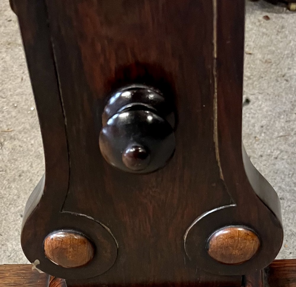 A Regency period dark rosewood freestanding writing table featuring a dark leather insert top, carved scroll accents, a turned central stretcher, and carved feet. View V