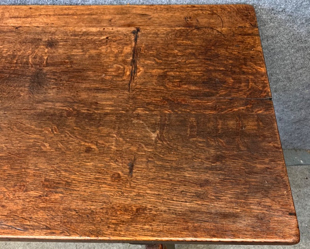A dark oak Spanish console table featuring two carved drawers, lyre-shaped trestle legs, and a scrolled wrought iron stretcher. View XIII