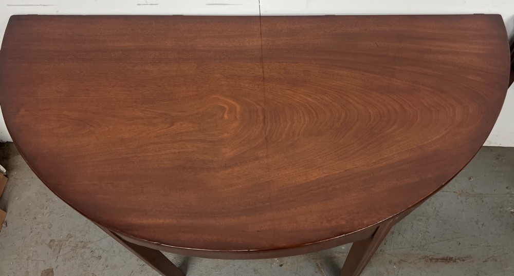 A pair of semi-circular George IV mahogany demilune console tables with polished surfaces and straight tapered legs. View III